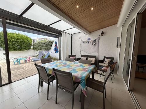 une salle à manger avec une table et des chaises dans l'établissement Maison avec véranda, proche océan, 3 chambres, parking privé - Saint-Jean-de-Monts - FR-1-224C-276, à Saint-Jean-de-Monts