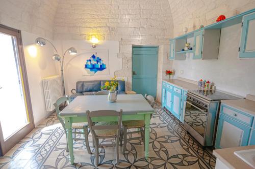 una cucina con mobili blu e un tavolo con sedie di Casa del Sud a Ostuni