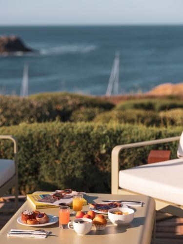 a table with plates of food on top of a balcony at Le Grand Large, Belle-Ile-En-Mer in Bangor