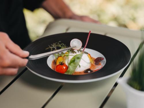 a person holding a plate of food on a table at Le Grand Large, Belle-Ile-En-Mer in Bangor