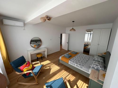 Un pequeño dormitorio con una cama y una silla. en Yaio Penthouse, en Agigea