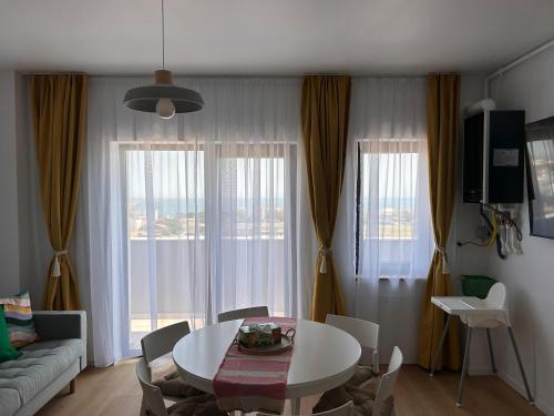 una sala de estar con una mesa y un sofá en Yaio Penthouse, en Agigea
