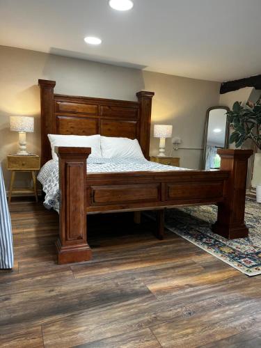 a large wooden bed in a bedroom with wooden floors at Spacious Cottage in Dartmoor in Hennock