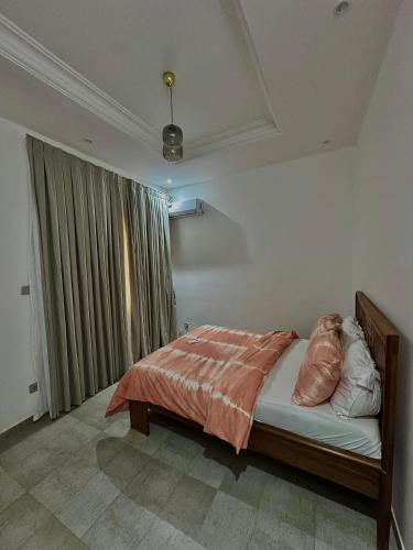 a bedroom with a bed with two pillows on it at Maisons d'Hotes Les jardins de keur fary 