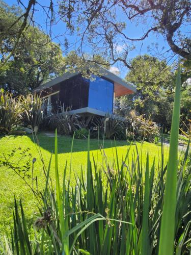 a house with a blue box in a garden at Cabana QUARTZO- Vista para PONTO TURISTIC0 Pedra Morro do Campestre- ACESSO até a cabana asfaltado in Urubici
