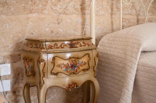 a gold end table next to a bed at Nel Cuore Del Salento Dimora Tipica in Calimera