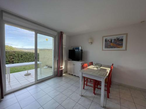 d'un salon avec une table et une télévision ainsi que d'un balcon. dans l'établissement Maison Duplex avec Piscines à Salavas - 6 Personnes, Animaux Admis, Parking, Terrasse et WiFi - FR-1-382-136, à Salavas