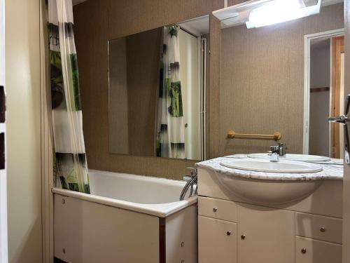 une salle de bain avec un lavabo et une baignoire dans l'établissement Appartement cosy pour 6 pers à Montgenèvre, 2 balcons, proche Chalmettes ! - FR-1-330D-87, à Montgenèvre