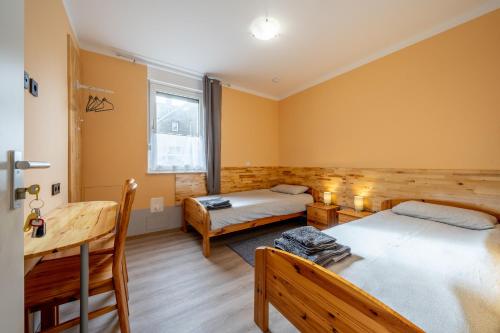 a room with two beds and a table and a desk at Kompaktes Studiozimmer mit Pantryküche und Fußbodenheizung in der Nähe der Messe Dusche und WC werden gemeinschaftlich genutzt in Hannover