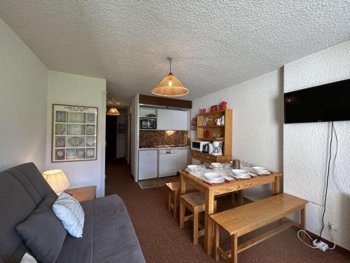 un salon avec une table et une cuisine dans l'établissement Appartement cosy pour 6 pers à Montgenèvre, 2 balcons, proche Chalmettes ! - FR-1-330D-87, à Montgenèvre