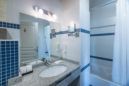 a bathroom with a sink and a mirror at Hotel Restaurant Le Gardon - Pont du Gard in Collias