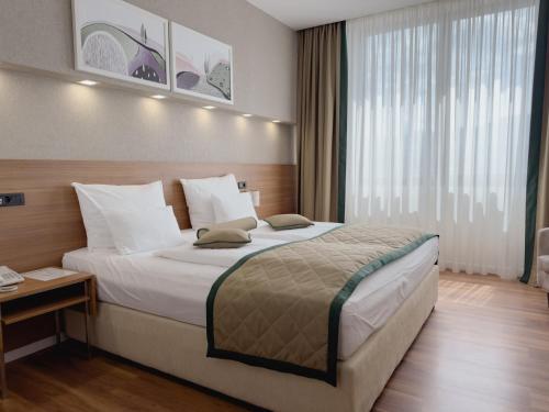 a hotel room with a bed and a large window at Hotel Via Vitez in Vitez