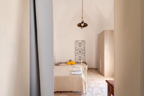 a bedroom with a bed in a white room at Nel Cuore Del Salento Dimora Tipica in Calimera
