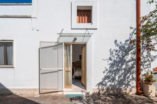 a glass door leading into a white house at Nel Cuore Del Salento Dimora Tipica in Calimera