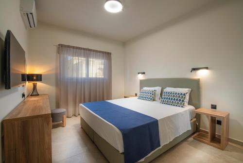 a bedroom with a large bed and a window at Amore Protaras Apartments in Paralimni
