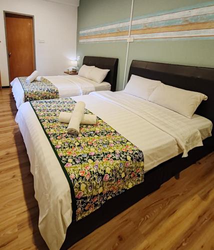 two beds sitting next to each other in a room at Treeline Urban Inn in Kota Kinabalu