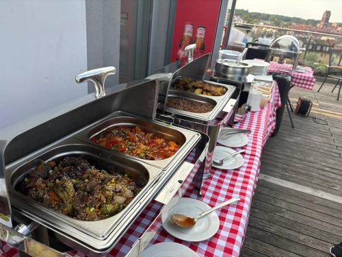 a buffet line with dishes of food on a table at Apartamenty Rondo in Świnoujście