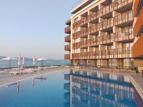 a hotel with a swimming pool in front of a building at Stylish Paradiso Apartment 206 in Nesebar