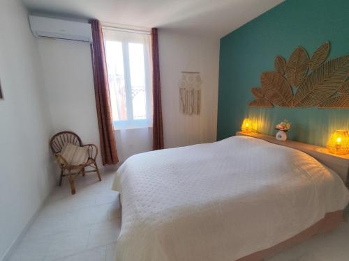 a bedroom with a large bed with two lights on it at Appartement cosy village entre mer et nature in Le Pradet