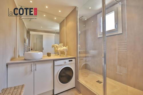 a bathroom with a washing machine and a shower at Melusine in Sausset-les-Pins