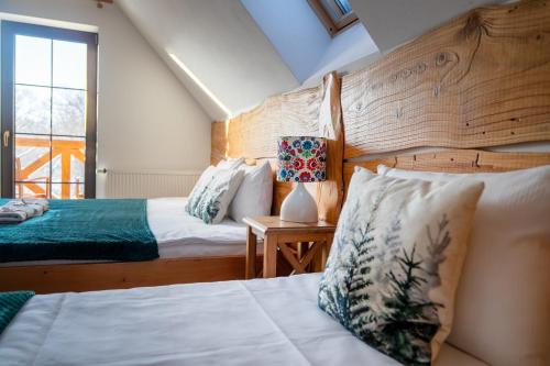 a bedroom with two beds and a window at Tarninowe Wzgórze in Kunkowa