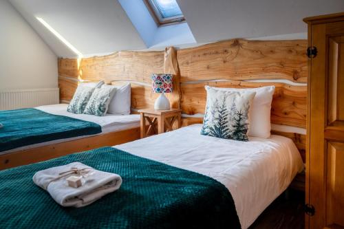 a bedroom with two beds with green sheets at Tarninowe Wzgórze in Kunkowa