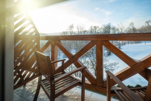 a rocking chair on the balcony of a house at Tarninowe Wzgórze in Kunkowa
