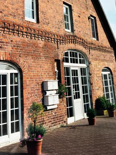 a brick building with two windows and two suitcases at Ferienwohnung AllerStall in Marklendorf