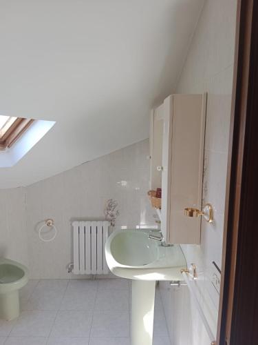 a white bathroom with a sink and a toilet at Hostal Acantilado in Villadaíde