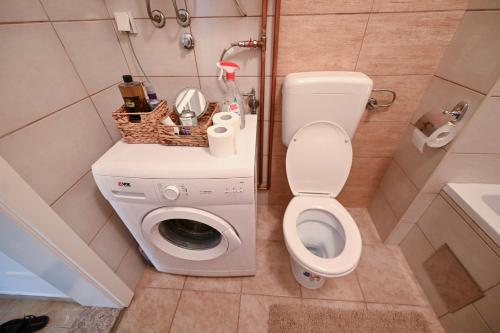 a bathroom with a toilet and a washing machine at Olja in Sarajevo