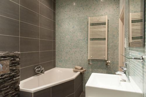 a bathroom with a tub and a toilet and a sink at Livia's Hideaway Canalbelt in Amsterdam