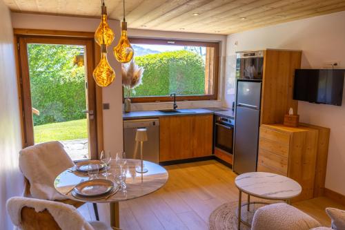 une cuisine avec une table et des chaises et une cuisine avec un évier dans l'établissement L échappée Belle, à Megève
