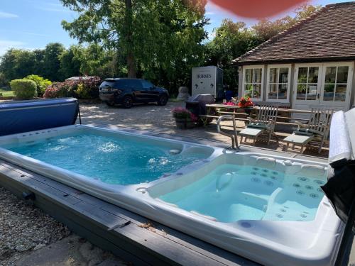 a jacuzzi tub in a yard next to a house at Molland Manor House Bed & Breakfast in Sandwich