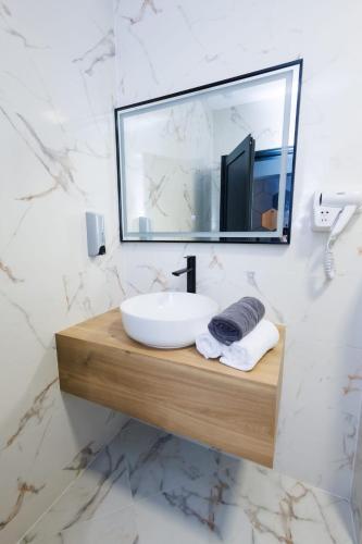 a bathroom with a sink and a mirror at Boulevard Hotel in Aytos