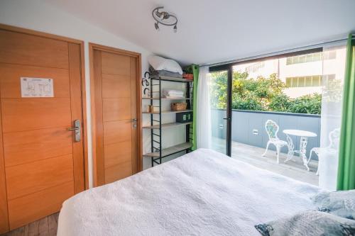 a bedroom with a bed and a sliding glass door at AYCA La Flora Hotel Boutique in Valparaíso