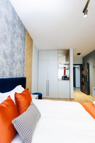 a bedroom with a large white bed with orange pillows at Boulevard Hotel in Aytos