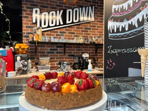a cake with strawberries and oranges on top of a counter at Apartamenty Rondo in Świnoujście