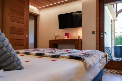 une chambre avec un lit et une télévision à écran plat dans l'établissement L échappée Belle, à Megève