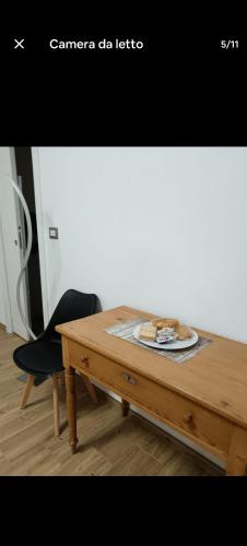 a wooden table with a black chair next to a table at Room private Ossi in Ossi
