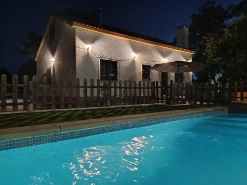 a house and a swimming pool at night at A Casa da Carrasqueira, Sesimbra in Sesimbra