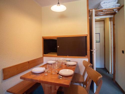 - une table en bois avec des chaises et une télévision dans la chambre dans l'établissement Studio divisible avec terrasse, animaux acceptés - FR-1-291-783, à Valmorel