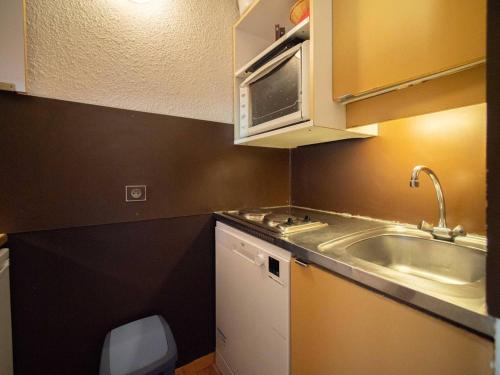 une petite cuisine avec un évier et un micro-ondes dans l'établissement Studio divisible avec terrasse, animaux acceptés - FR-1-291-783, à Valmorel