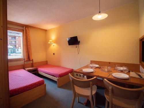 une pièce avec une table et un lit et une table et des chaises dans l'établissement Studio divisible avec terrasse, animaux acceptés - FR-1-291-783, à Valmorel