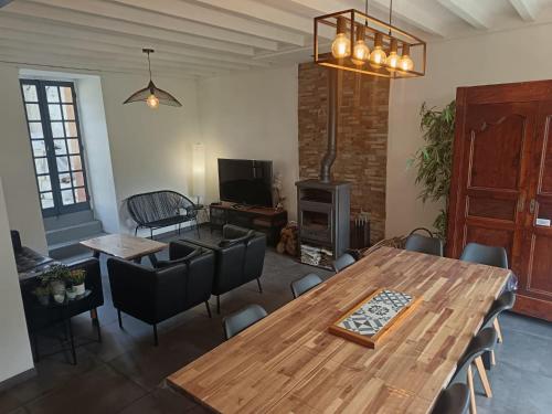 un salon avec une table et des chaises en bois dans l'établissement Grand gîte au coeur d'un charmant village, à Miglos