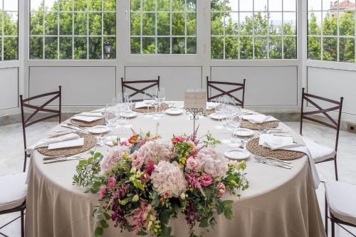 a table with flowers on it in a room with windows at Eurostars Hotel Real in Santander