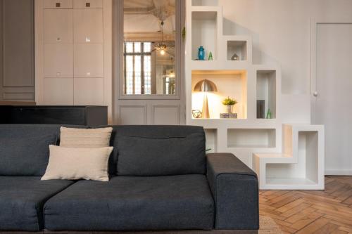 a living room with a blue couch in a room at Lille Centre - Grand Studio atypique ! in Mons-en-Baroeul
