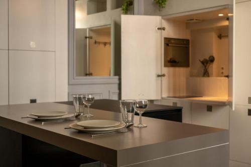 a kitchen with a table with plates and wine glasses at Lille Centre - Grand Studio atypique ! in Mons-en-Baroeul