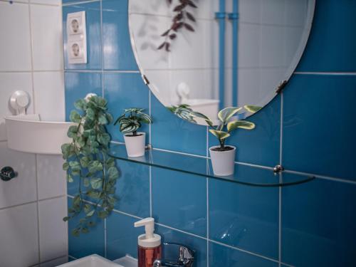 a bathroom with a mirror and potted plants on the wall at Chic Asboth City Center Loft - Perfect Location in Budapest
