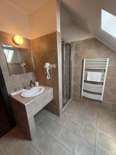 a bathroom with a sink and a shower at Caballus Lovasmajor Panzió in Nyíregyháza