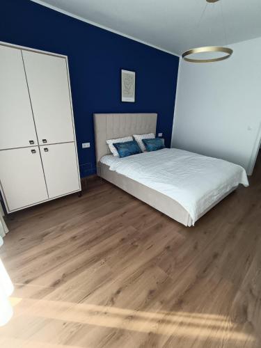 a bedroom with a bed and a blue wall at B&B ApartHotel in Bistriţa